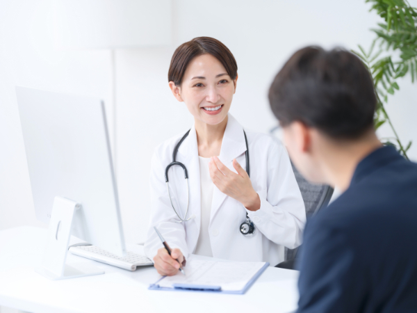歯の神経の治療中の痛みについて説明する歯科医師